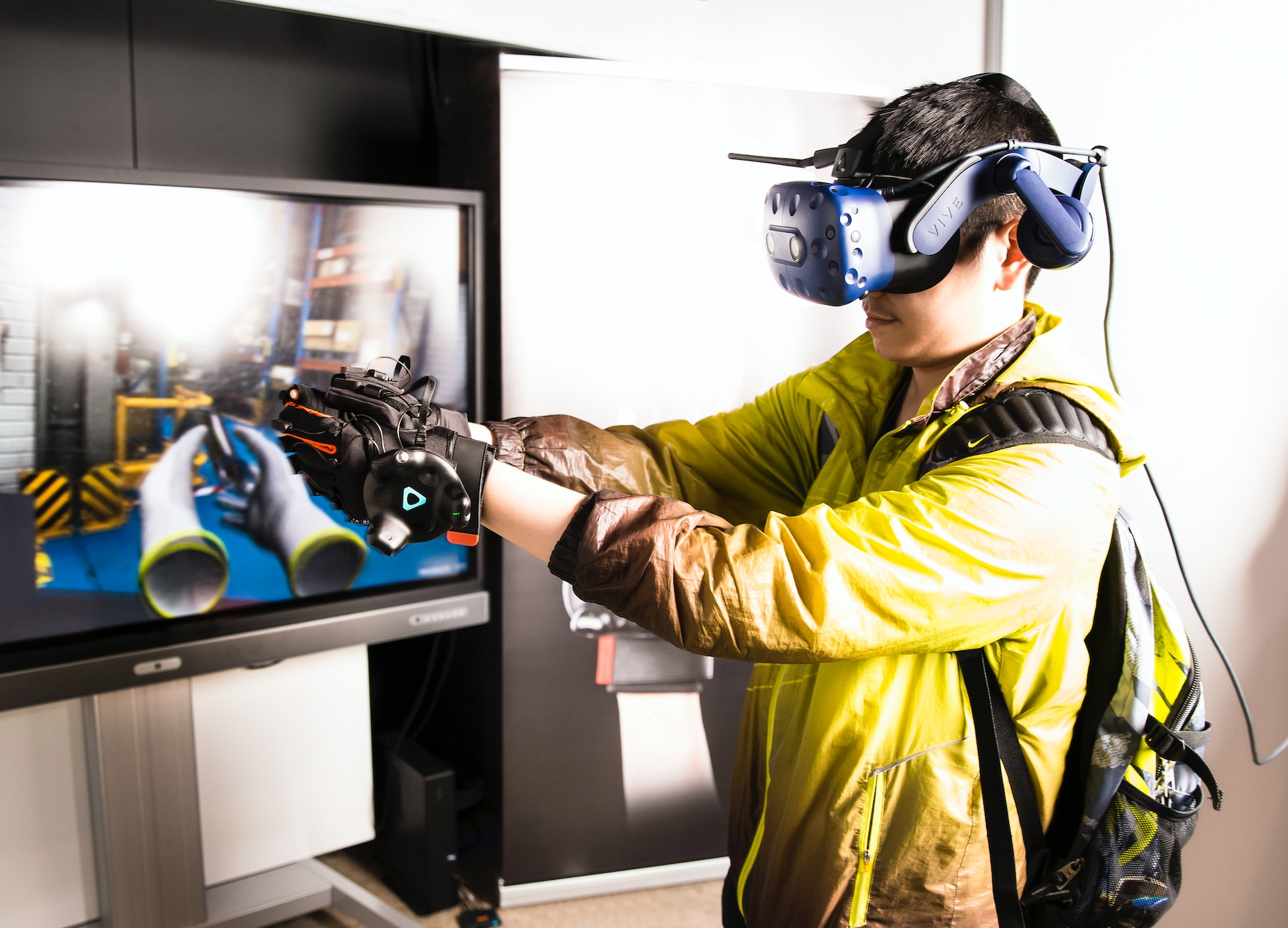 Fully immersed man using vive htc with haptics gloves during the industrial training simulation